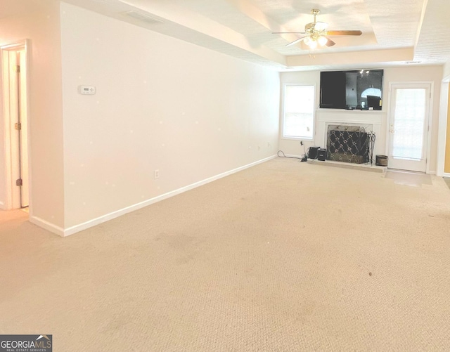 127 Mabry Rd, Jackson, GA 30233 - unfurnished living room featuring a tray ceiling, baseboards, ceiling fan, and light carpet