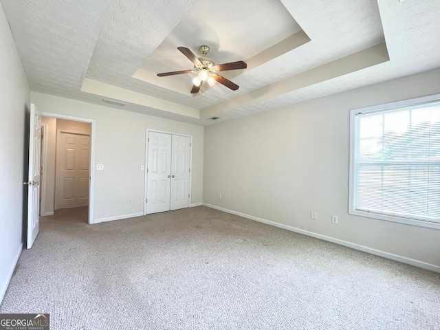 127 Mabry Rd, Jackson, GA 30233 - unfurnished bedroom featuring a tray ceiling, light carpet, ceiling fan, and a closet