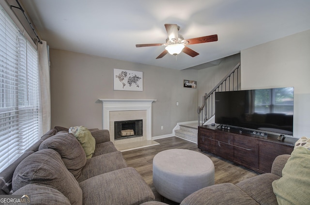 3186 Sail Winds Dr NW, Acworth, GA 30101 - living area featuring wood finished floors, baseboards, stairway, a fireplace with raised hearth, and a ceiling fan
