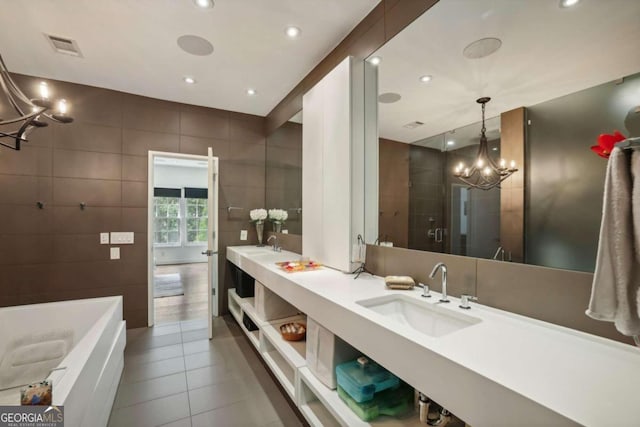 full bath featuring tile patterned flooring, an inviting chandelier, a bath, a sink, and a stall shower