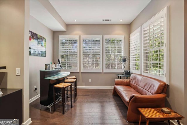 sitting room with wood-type flooring, baseboards, and visible vents