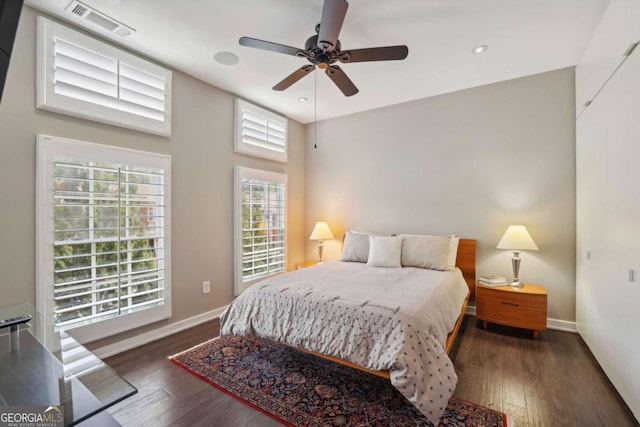 bedroom featuring a ceiling fan, baseboards, visible vents, and wood finished floors