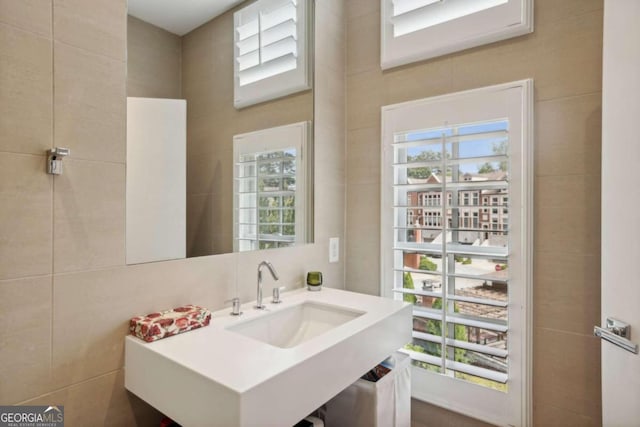bathroom with a sink and tile walls