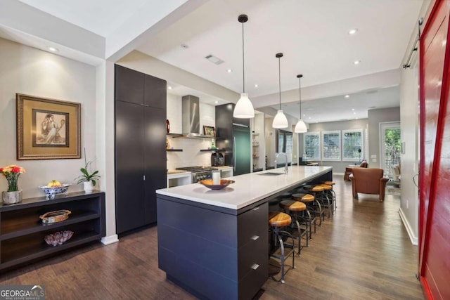 kitchen with a sink, dark wood-style floors, modern cabinets, and wall chimney exhaust hood