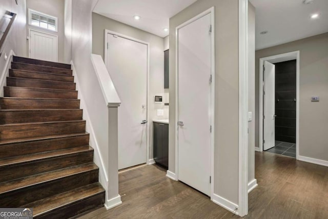staircase with baseboards, recessed lighting, and wood finished floors