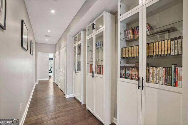 hallway featuring baseboards, recessed lighting, and dark wood-type flooring