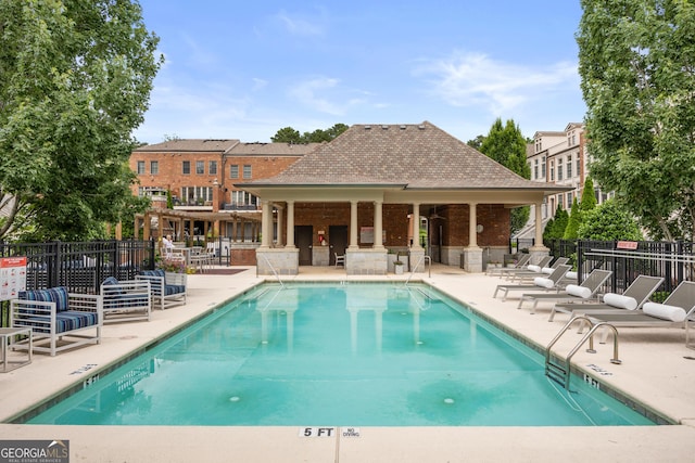community pool featuring fence and a patio area