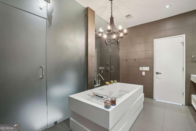 full bathroom with an inviting chandelier, visible vents, tile walls, tile patterned floors, and a shower stall