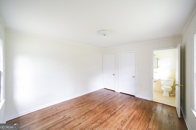 120 Hunt Rd, Athens, GA 30606 - unfurnished bedroom with crown molding, baseboards, wood finished floors, and ensuite bathroom