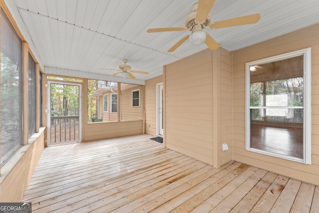 unfurnished sunroom with ceiling fan