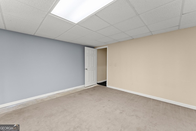 carpeted spare room with baseboards and a paneled ceiling