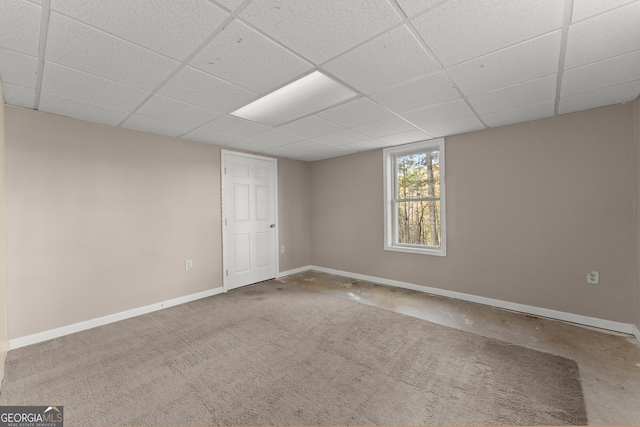 interior space with baseboards and a drop ceiling