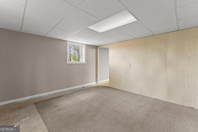 basement with wooden walls and a drop ceiling