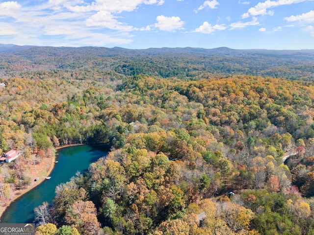 aerial view with a water and mountain view and a wooded view