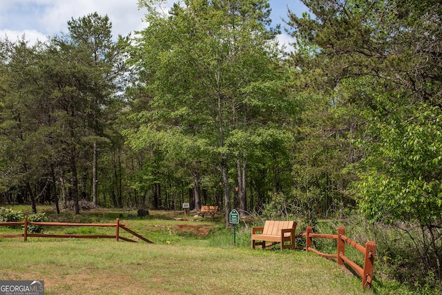 view of yard featuring fence and a wooded view
