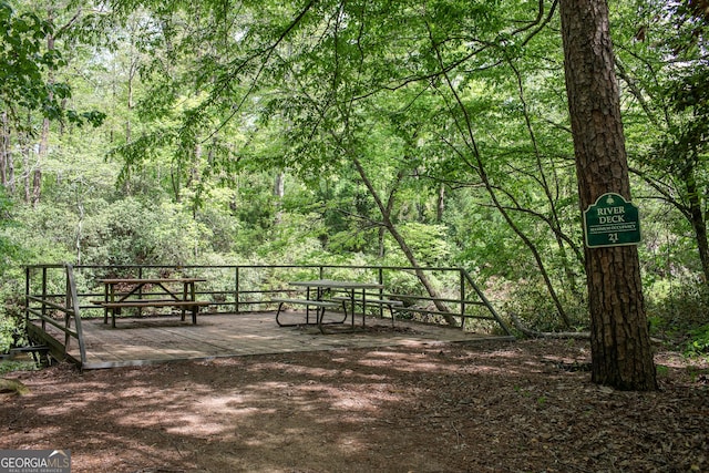 surrounding community featuring a deck and a forest view