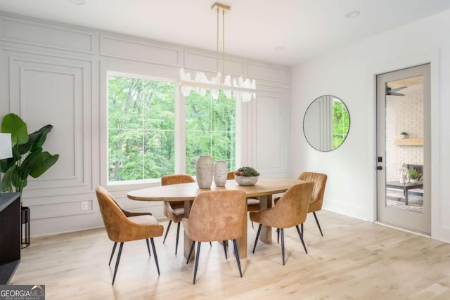 dining room with light wood-style flooring and a decorative wall