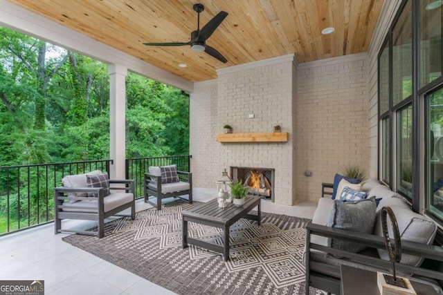 view of patio / terrace featuring an outdoor living space with a fireplace and ceiling fan