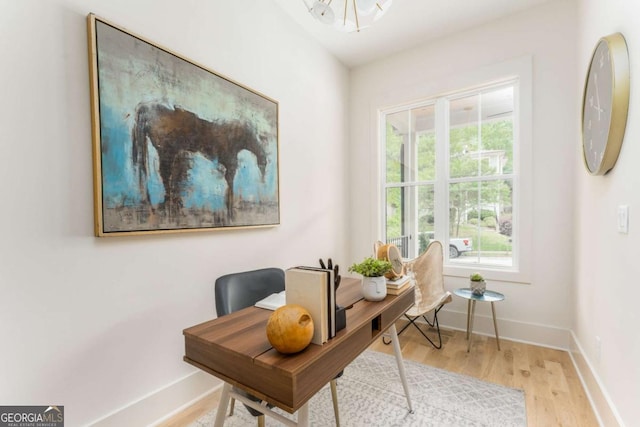 office space with baseboards, wood finished floors, and a notable chandelier