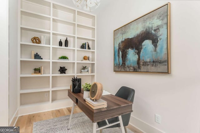 office featuring baseboards, an inviting chandelier, and wood finished floors
