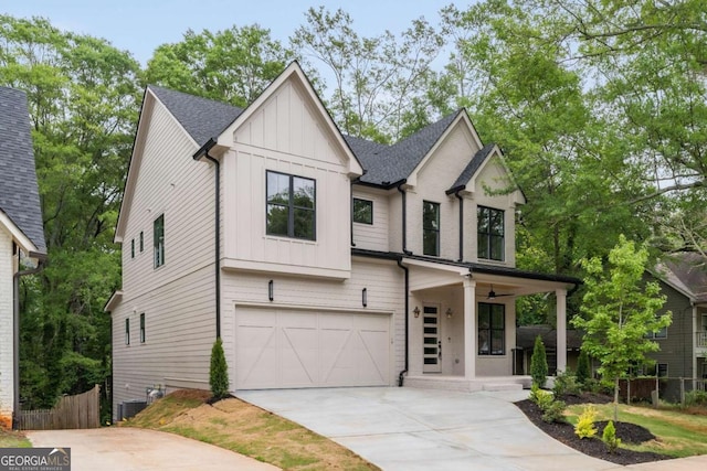view of front facade with board and batten siding, a porch, driveway, a garage, and fence