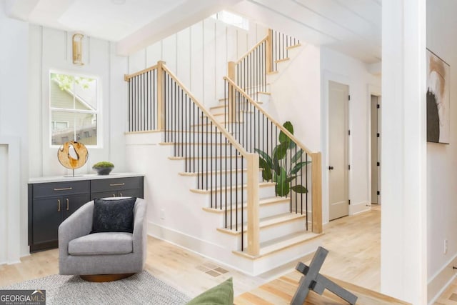 stairs featuring baseboards, visible vents, and wood finished floors
