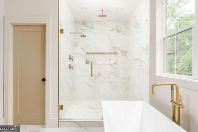 bathroom with a marble finish shower and a soaking tub