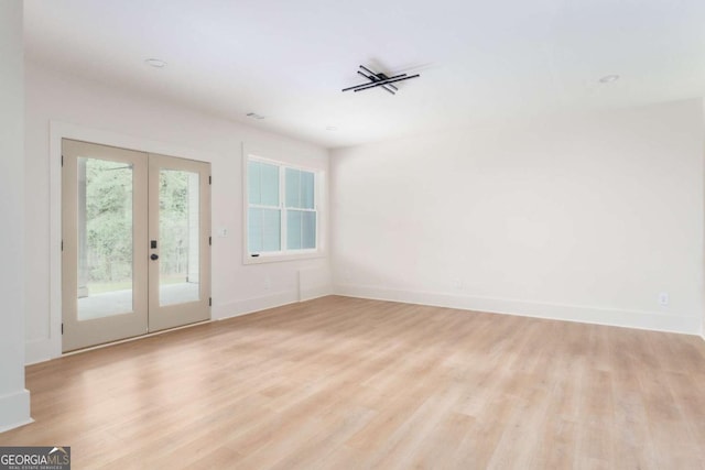 interior space with french doors, baseboards, and light wood-type flooring