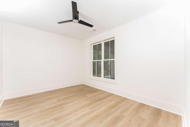 empty room with baseboards, ceiling fan, and light wood finished floors