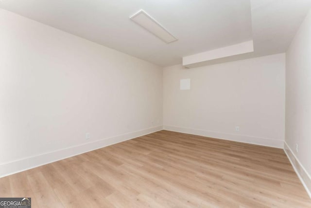 spare room featuring light wood-style floors and baseboards