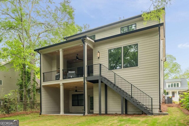 back of house with stairs, a ceiling fan, fence, and a balcony