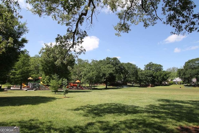view of home's community featuring a yard and playground community