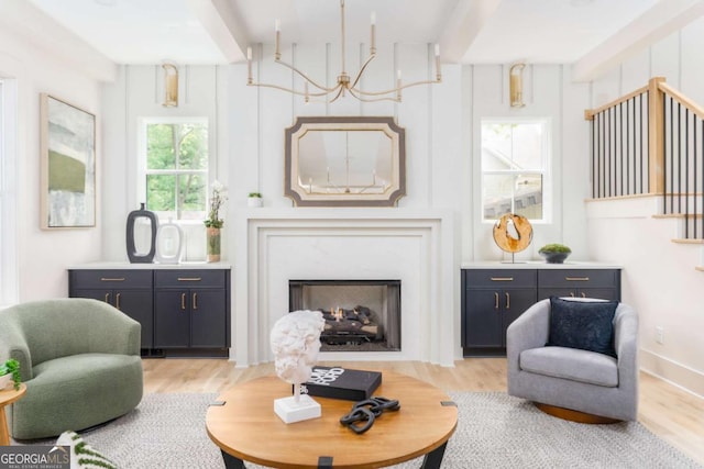 sitting room with light wood-style flooring and a premium fireplace