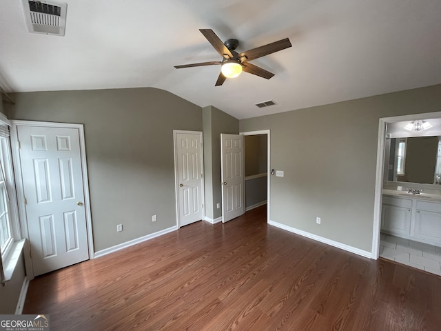 211 Buckland Dr, Alpharetta, GA 30022 - unfurnished bedroom with wood finished floors, lofted ceiling, two closets, baseboards, and a sink