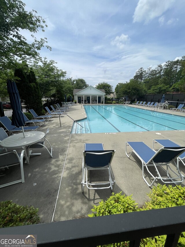 211 Buckland Dr, Alpharetta, GA 30022 - community pool featuring fence, a patio, and view of scattered trees