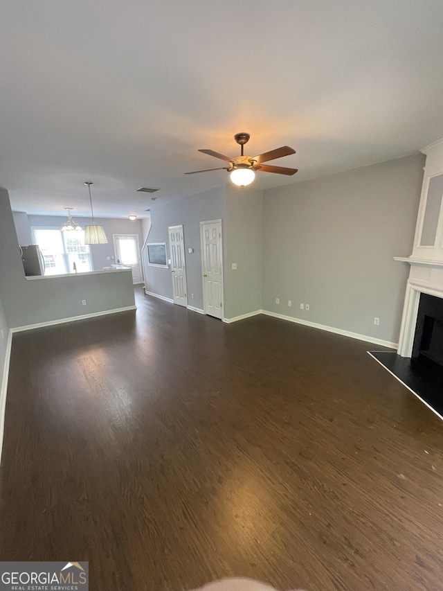 211 Buckland Dr, Alpharetta, GA 30022 - unfurnished living room featuring a fireplace with raised hearth, dark wood-type flooring, baseboards, and a ceiling fan