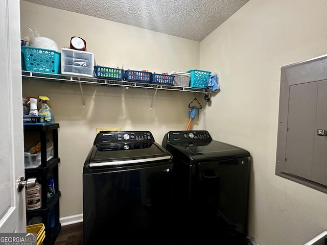 clothes washing area with laundry area, separate washer and dryer, a textured ceiling, dark wood finished floors, and electric panel