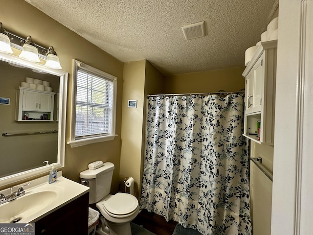 full bathroom with visible vents, a textured ceiling, toilet, and vanity