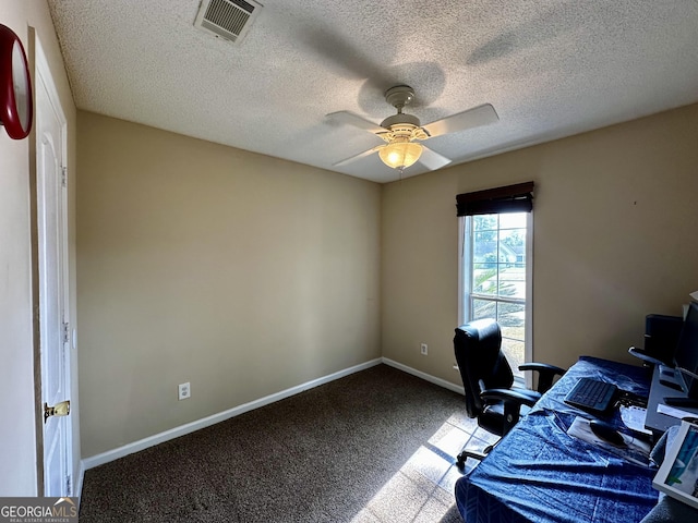 office space with visible vents, carpet floors, baseboards, ceiling fan, and a textured ceiling
