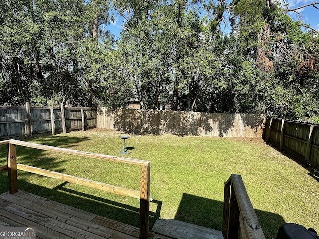 view of yard with a fenced backyard and a wooden deck