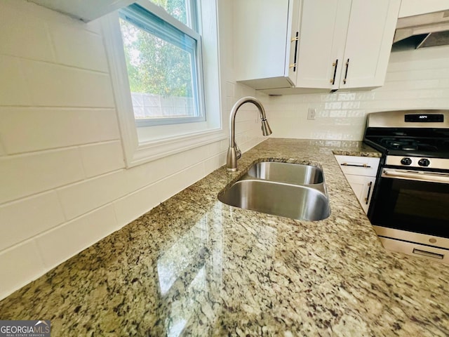 2502 Barge Rd SW, Atlanta, GA 30331 - kitchen with light stone counters, a sink, stainless steel range with gas cooktop, white cabinetry, and under cabinet range hood