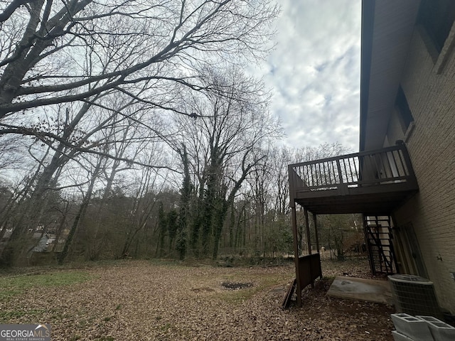 view of yard featuring stairs, central AC, and a deck