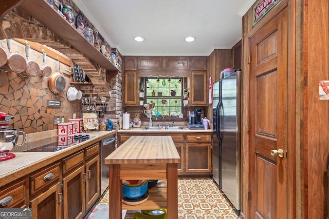 kitchen featuring a sink, appliances with stainless steel finishes, ornamental molding, and butcher block counters