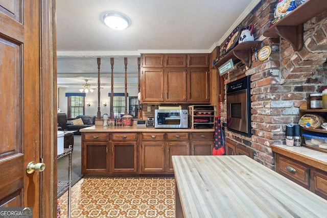 kitchen featuring light countertops, stainless steel appliances, ceiling fan, and ornamental molding
