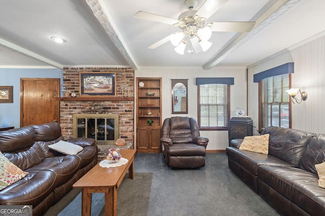 carpeted living room with crown molding, ceiling fan, a fireplace, and beam ceiling