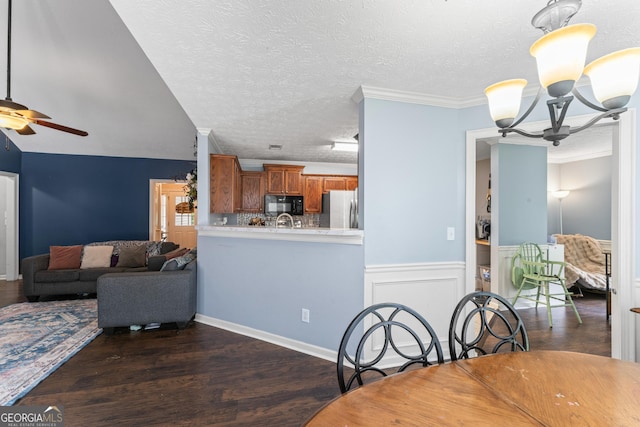 308 Dylan Way, Mcdonough, GA 30252 - dining area featuring ceiling fan, a chandelier, dark wood-style flooring, wainscoting, and a textured ceiling