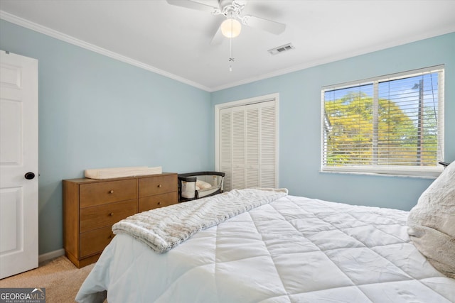 bedroom with visible vents, crown molding, a closet, light carpet, and baseboards