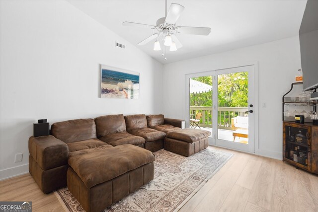 living room with visible vents, light wood finished floors, ceiling fan, and lofted ceiling