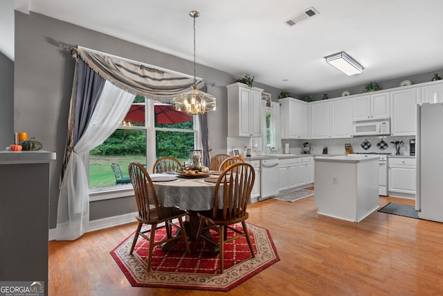 dining room featuring visible vents, an inviting chandelier, and light wood-type flooring