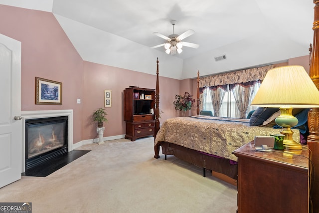 carpeted bedroom featuring a ceiling fan, baseboards, a fireplace with flush hearth, lofted ceiling, and visible vents